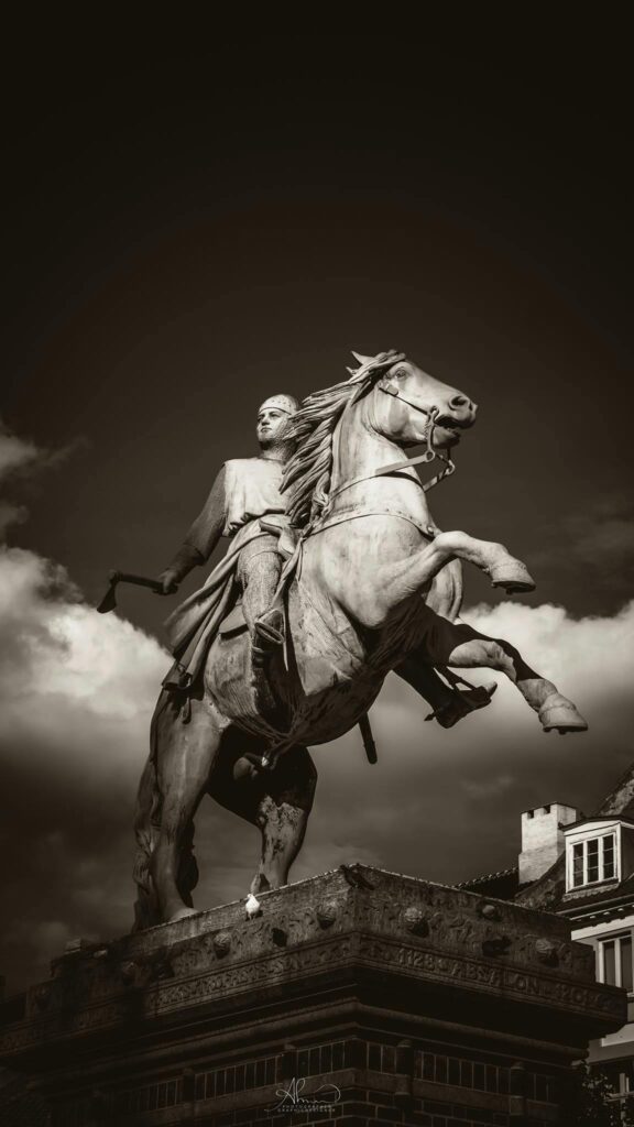 Kontakt Striking sepia-toned equestrian statue under cloudy Copenhagen sky.